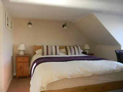 a bedroom with a large bed and two lamps at Harbour Lights Guesthouse in Stranraer