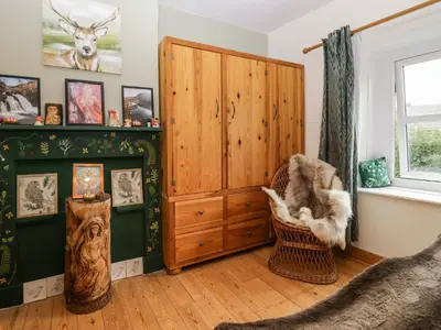 a room with a fireplace and a wooden cabinet at Whitecroft Nook in Seascale