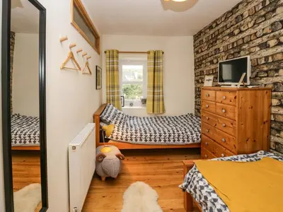 a bedroom with two twin beds and a mirror at Whitecroft Nook in Seascale