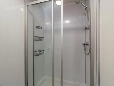 a shower with a glass door in a bathroom at West Morton House in Thornhill