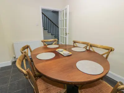 a wooden table with two chairs and a table and a table at West Morton House in Thornhill