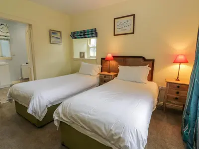 two beds in a room with two lamps on tables at Kilnmark Farmhouse in Thornhill
