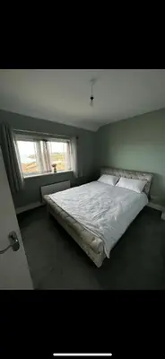 a large bed in a bedroom with a window at Beach villa in Parton