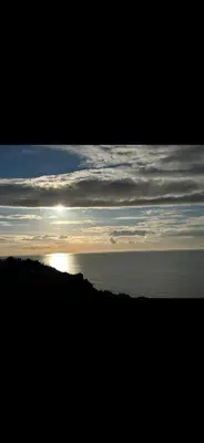 an image of the sun setting over the ocean at Beach villa in Parton