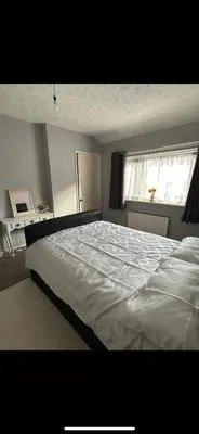 a large white bed in a bedroom with a window at Beach villa in Parton