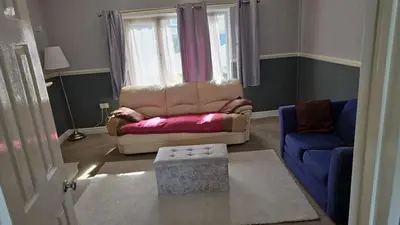 a living room with a couch and a blue chair at Beach villa in Parton