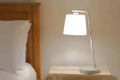a lamp sitting on a table next to a bed at Stylish retreat in Langdale in Chapel Stile