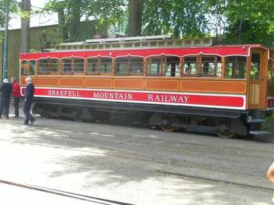 a red train car with people standing next to it at isleofmanholidayapartment in Douglas