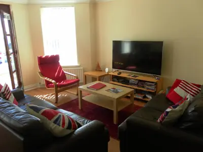 a living room with two couches and a flat screen tv at isleofmanholidayapartment in Douglas
