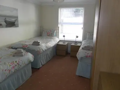 a bedroom with two twin beds and a window at isleofmanholidayapartment in Douglas