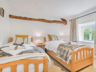 a bedroom with two beds and a window at 4 Bed in Ulpha SZ183 in Ulpha