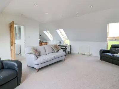 a living room with a couch and two chairs at Seascape in Dalbeattie