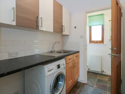 a kitchen with a washing machine and a sink at Seascape in Dalbeattie