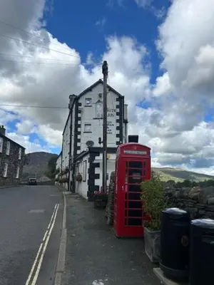 a red phone booth sitting on the side of a street at The White Lion Inn in Penrith