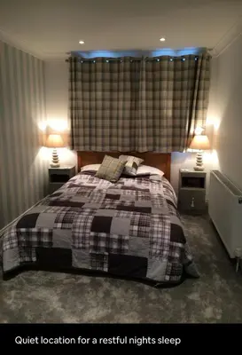 a bedroom with a bed with two lights on at Beach room in Ayr
