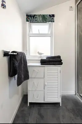 a bathroom with a white sink and a window at Beach room in Ayr