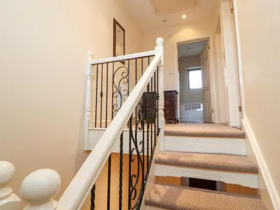 a staircase in a house with white walls and wooden floors at Valley View in Cleator Moor