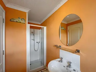 a bathroom with a shower and a sink and a mirror at Tredegar in Newton Stewart