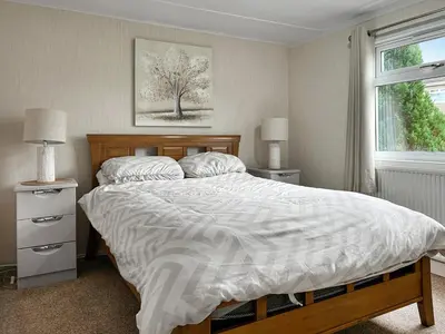 a bedroom with a bed and two night stands and a window at Lisset in Newton Stewart