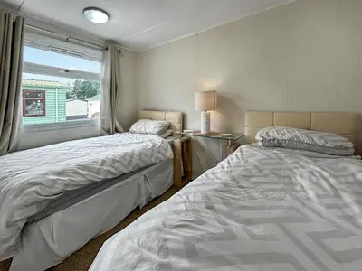 two beds in a small room with a window at Lisset in Newton Stewart