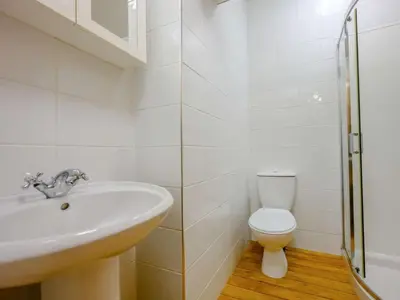 a white bathroom with a sink and a toilet at The Gables in Keswick
