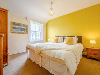 a bedroom with a large bed with yellow walls at The Gables in Keswick