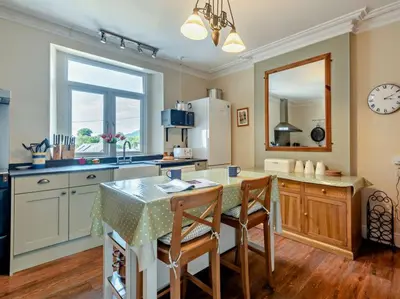 a kitchen with a table and two chairs and a counter at The Gables in Keswick