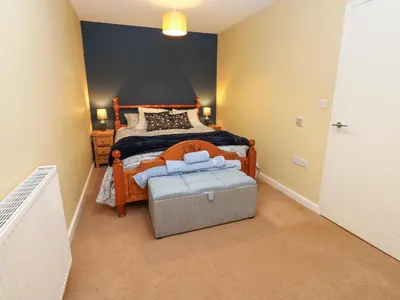 a bedroom with a large bed with a wooden frame at The Nest in Carlisle