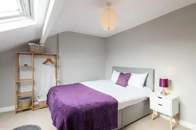 a bedroom with a bed with a purple blanket at Hampton Manor House - 9 Bedrooms in St Bees