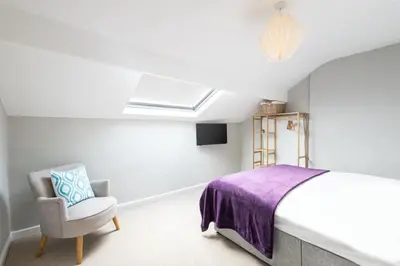 a bedroom with a bed and a chair at Hampton Manor House - 9 Bedrooms in St Bees