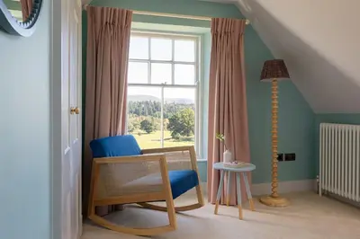 a room with a chair and a window at Queensberry Cottage in Thornhill