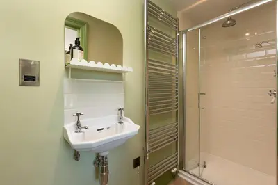 a bathroom with a sink and a shower at Queensberry Cottage in Thornhill