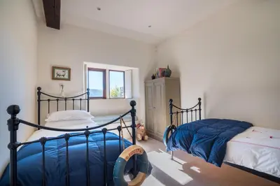 a bedroom with two beds with blue sheets at Bank Barn, Wreay in Penrith