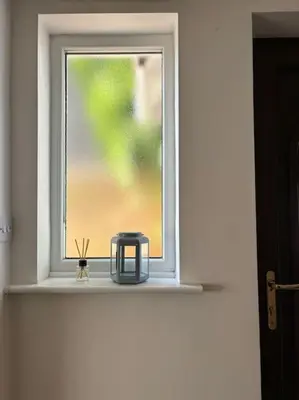 a window with a blue container sitting on a window sill at Cosy Cumbrian home away from home in Whitehaven