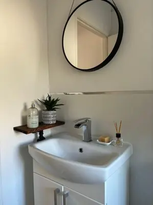 a bathroom with a sink and a mirror on the wall at Cosy Cumbrian home away from home in Whitehaven