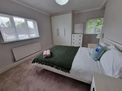 a bedroom with a bed with two pink shoes on it at Cosy Cumbrian home away from home in Whitehaven