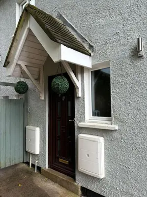 a house with a door and a window and two boxes at Cosy Cumbrian home away from home in Whitehaven