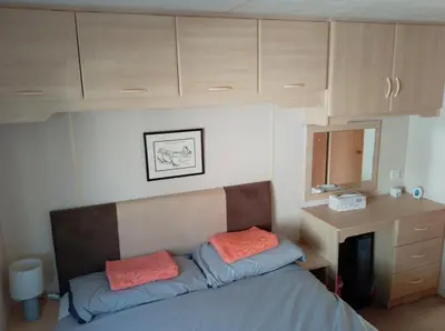 a bedroom with a bed and a desk and cabinets at Cairnryan - Loch Ryan View in Cairnryan