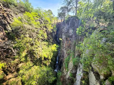 a waterfall on the side of a mountain at 1 Bed in Eskdale 95105 in Eskdale