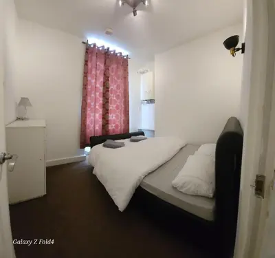 a small bedroom with a bed and a window at Flat 2 Douglas Head Road in Douglas