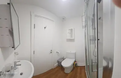 a white bathroom with a toilet and a shower at Flat 2 Douglas Head Road in Douglas