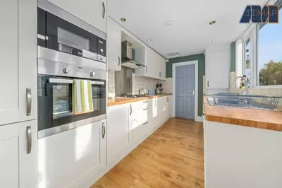 a large kitchen with white cabinets and a counter top at Carlisle 3Bed Sleeps 6 in Carlisle