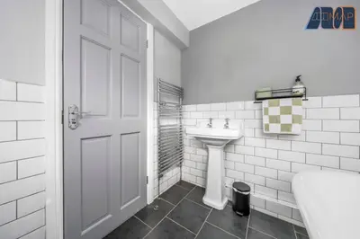 a white bathroom with a sink and a white door at Carlisle 3Bed Sleeps 6 in Carlisle