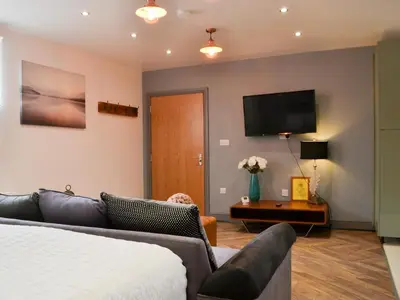 a living room with a couch and a flat screen tv at Haaf Netters Rest - Uk43557 in Bowness-on-Solway