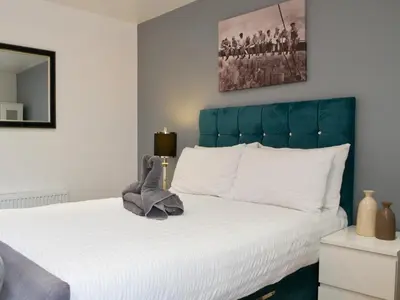 a bedroom with a large white bed with a blue headboard at Haaf Netters Rest - Uk43557 in Bowness-on-Solway