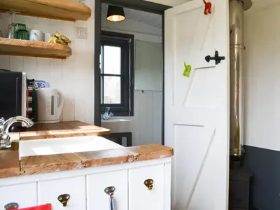 a kitchen with a sink and a white door at Sian's Shepherds Hut - Uk43561 in Bowness-on-Solway