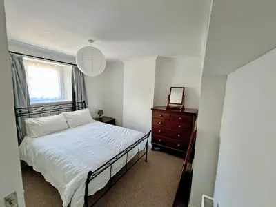 a bedroom with a bed and a window and a dresser at Coast To Coast Cottage in Cleator Moor