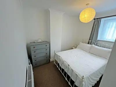 a small bedroom with a bed and a window at Coast To Coast Cottage in Cleator Moor
