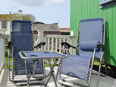 a pair of chairs and a table on a patio at Hannah's Shepherds Hut - Uk43564 in Bowness-on-Solway