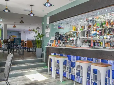 a bar in a restaurant with stools at Hannah's Shepherds Hut - Uk43564 in Bowness-on-Solway